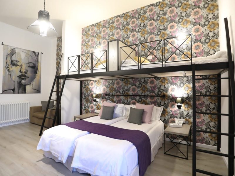 A family room with bunk beds and patterned wallpaper