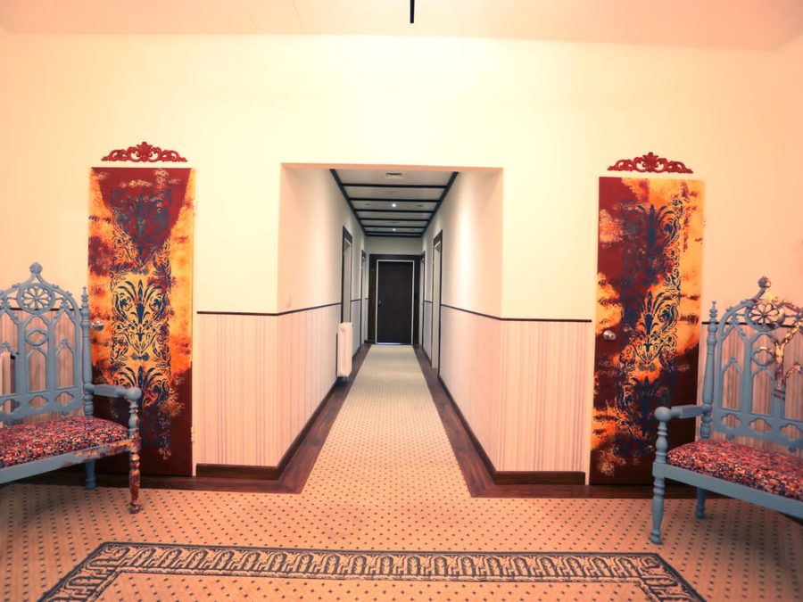 A guest corridor, with painted panels and antique chairs